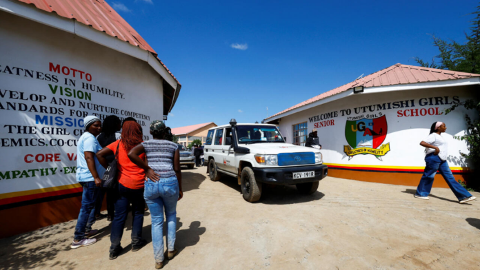 Una ambulancia de la Cruz Roja de Kenia sale de la Academia Femenina Utumishi, tras un incendio nocturno en un dormitorio del centro en Gilgil, condado de Nakuru, Kenia, el 28 de mayo de 2026.